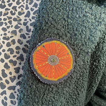 Broche fleur ronde Marguerite rouge portée